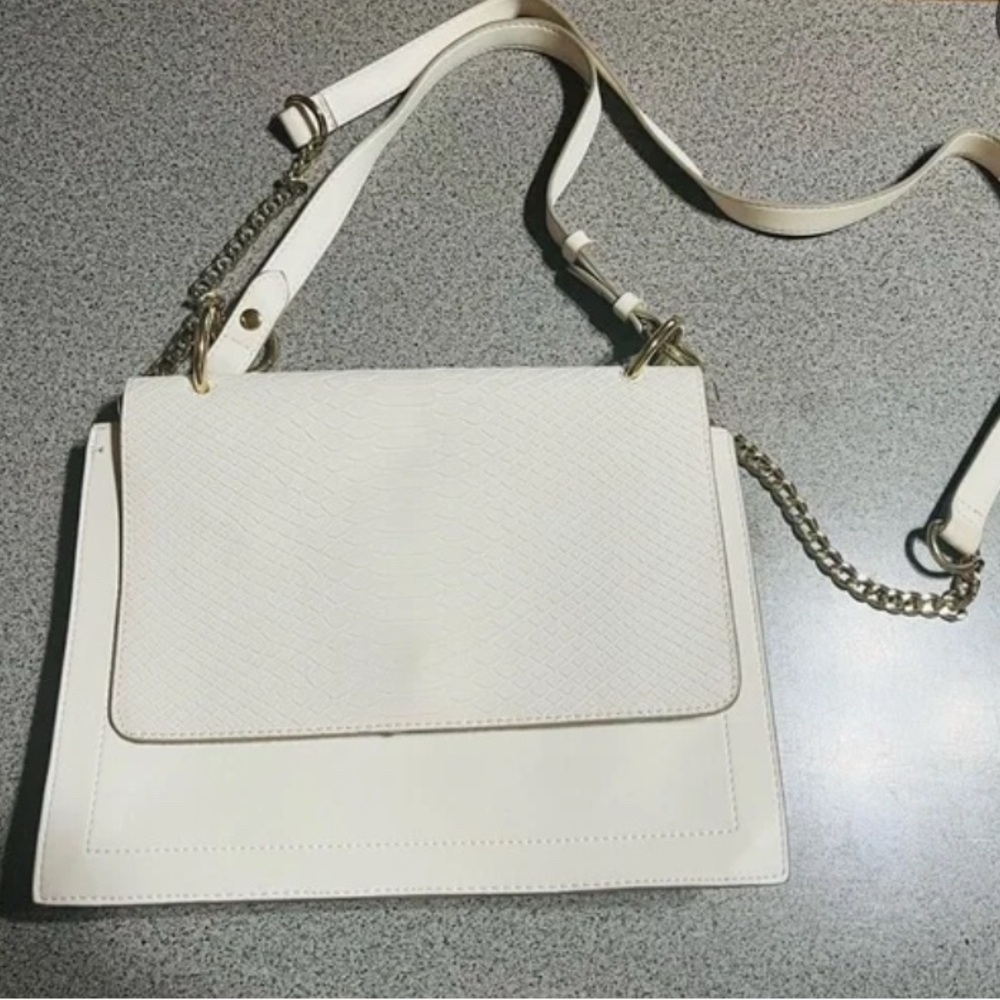 Express crossbody strap with chain hardware and a hand handle.